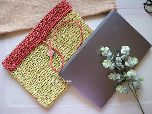 Handcrafted laptop sleeve with natural raffia fibers, offering protection and style.