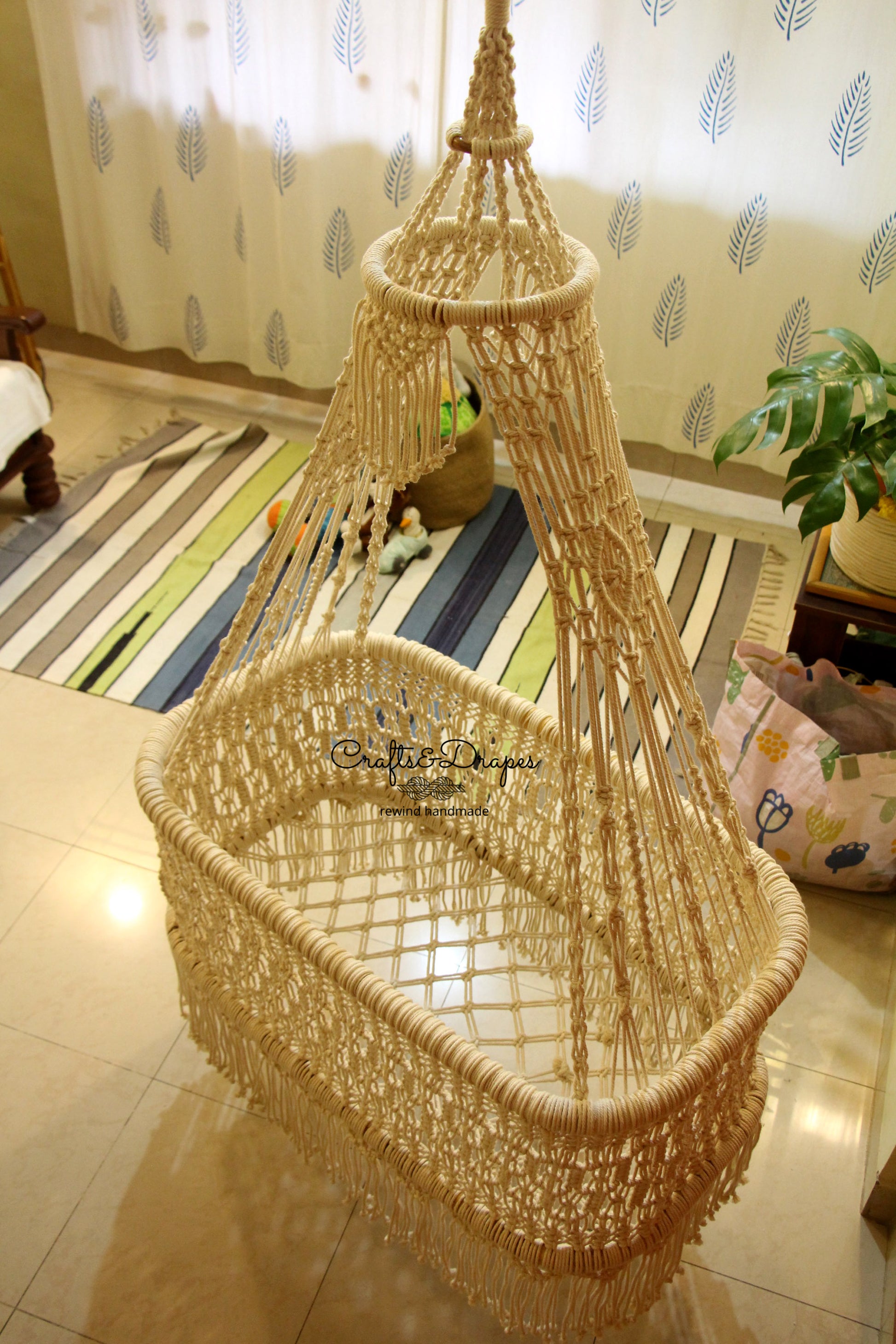 Create a cozy and ethereal atmosphere with this handcrafted macramé baby cradle, woven from premium, sustainable cotton cords and natural wooden materials.