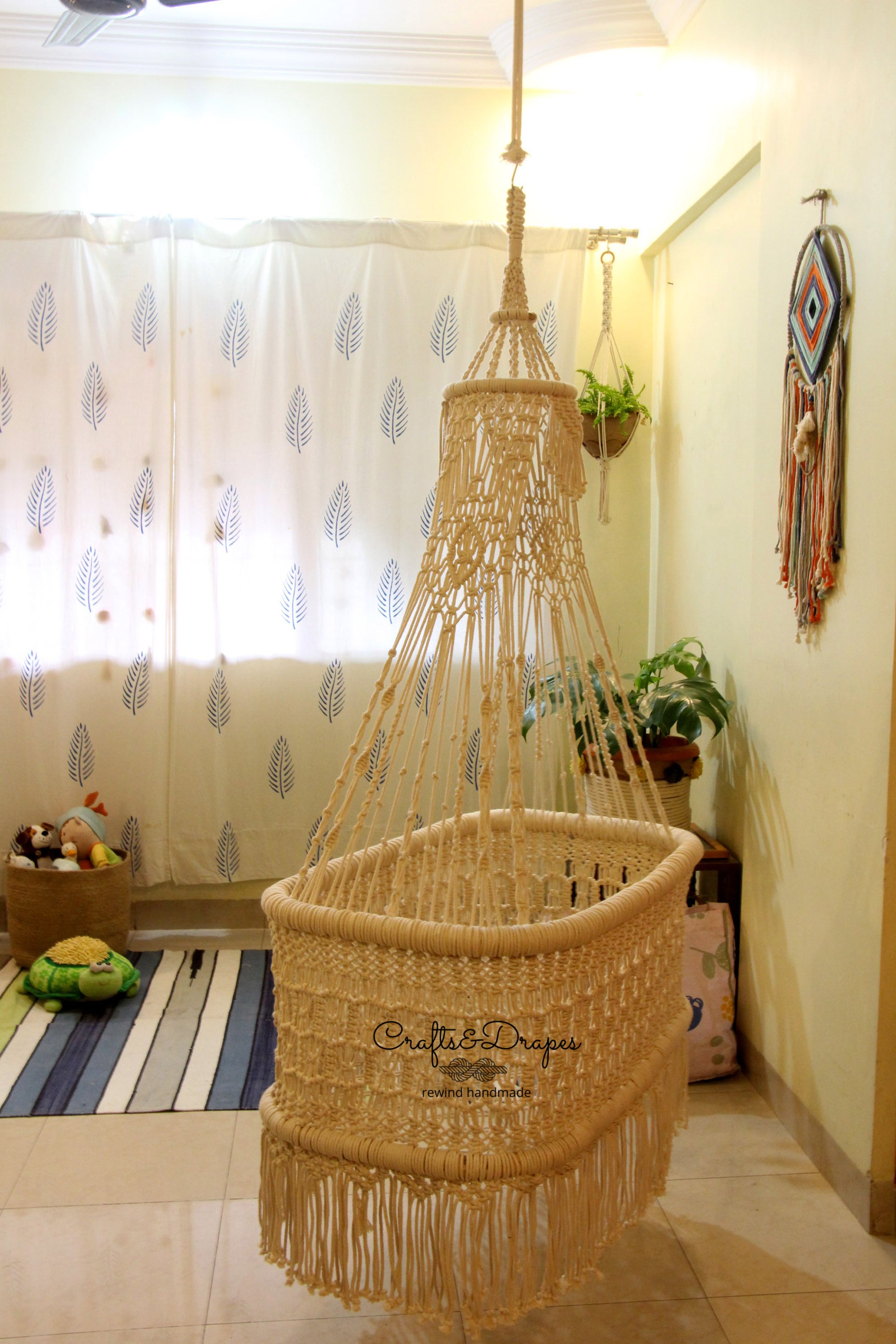 Elevate your nursery with this intricately designed macramé baby cradle, offering both style and comfort with its sustainable cotton cords and sturdy wooden frame.